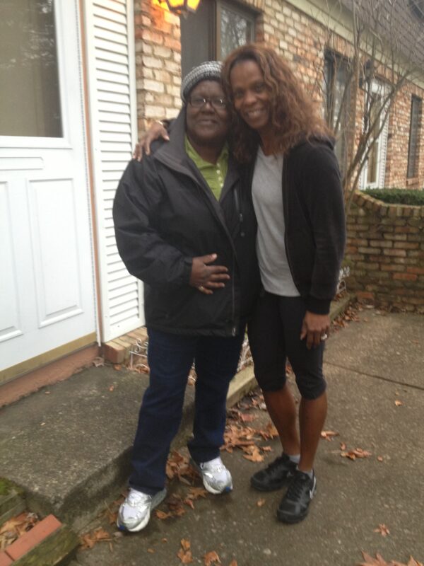 Kimberly and her mom out front, smiling from ear to ear in front of her new home